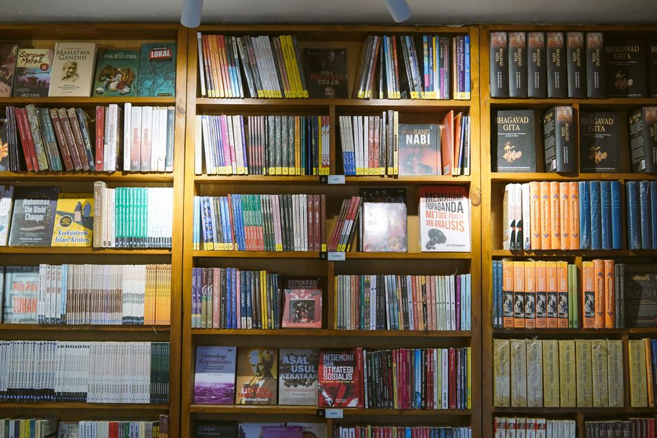 A wide view of bookshelves filled with various books, showcasing knowledge and diversity in a library setting.