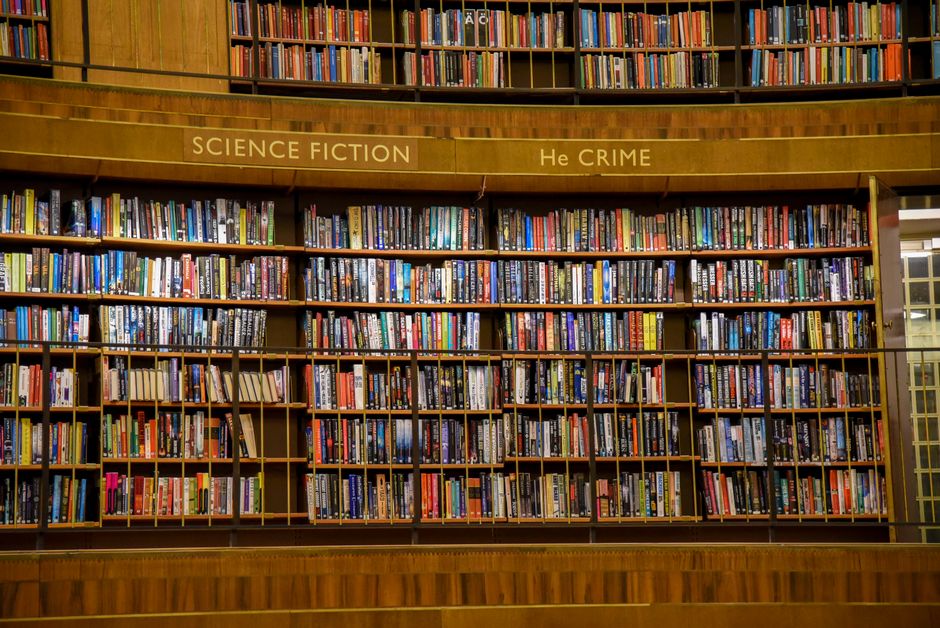 A wide view of bookshelves filled with various books, showcasing knowledge and diversity in a library setting.